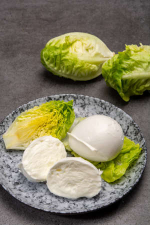 Ð¡heese collection, balls on soft white mozzarella bufala cheese served with green cos lettuce close upの写真素材