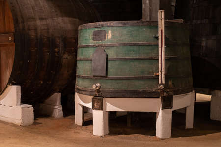 Old porto lodge with rows of oak wooden casks for slow aging of fortified ruby or tawny porto wine in Vila Nova de Gaia, north of Portugalの写真素材