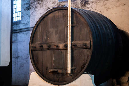 Old porto lodge with rows of oak wooden casks for slow aging of fortified ruby or tawny porto wine...