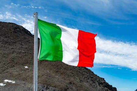 Green-white-red national italian flag waving on mast in sunny dayの写真素材