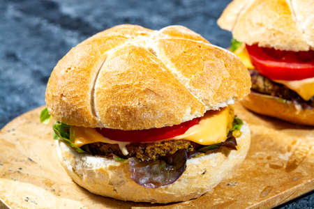 Healthy vegan or vegetarian fast food, fresh made plant based burgers with vegetables close upの写真素材
