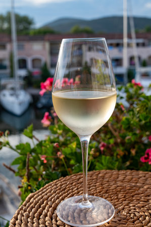 Tasting of local cold white wine in summer with sail boats haven of Port grimaud on background, Provence, Var, Franceの写真素材