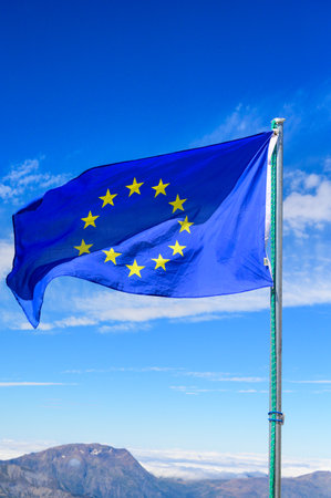 Blue with yellow stars Flag of Europe or European Union flag waving on mast in French Alpine mountains in sunny dayのeditorial素材