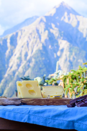 Tasty Swiss cheeses and dark pure chocolate, emmental, gruyere, appenzeller served outdoor with...