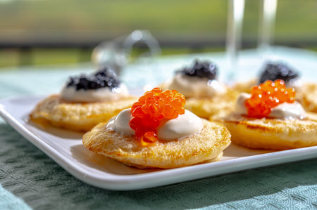 Tasting and pairing of french champagne wine with pancakes, creme fresh, red and black fish caviars...