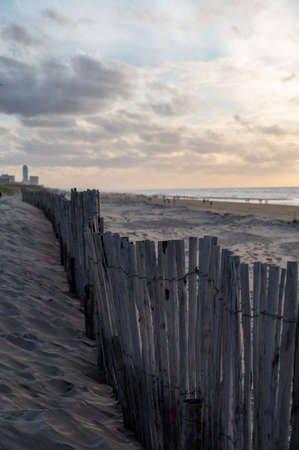 Sand fence on wide windy beach of North sea near Zandvoort in Netherlands in winterの写真素材