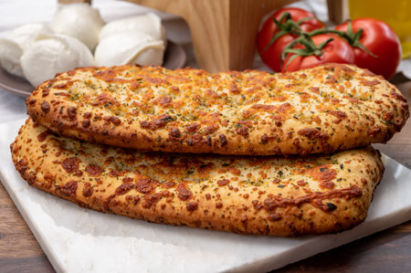 Tasty italian vegetarian food, fresh baked flat foccachia bread with white mozzarella cheese and...