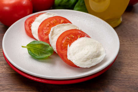 Tasty italian vegetarian food, fresh soft white mozzarella cheese served with red tomatoes and green basil c; pse upの写真素材
