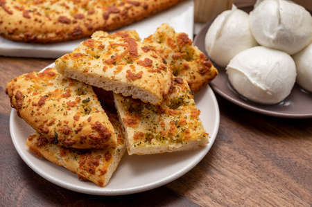 Tasty italian vegetarian food, fresh baked flat foccachia bread with white mozzarella cheese and...
