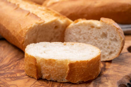 Ingredient for French breakfast, fresh baked crispy baguette white bread close up