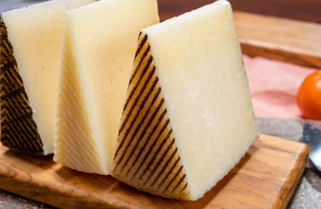 Cheese collection, pieces of hard Spanish manchego curado, viejo and iberico cheeses close upの写真素材