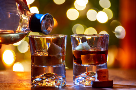 Glasses of single malt and blended scotch whiskey served in bar in Edinburgh, Scotland, UK with party lights on backgroundの写真素材