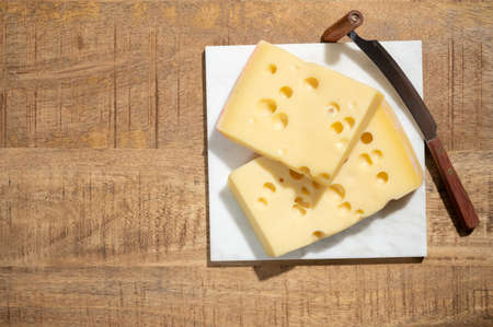 Cheese collection, blocks of French Emmentaler cheese with many round holes made from cow milk close upの写真素材