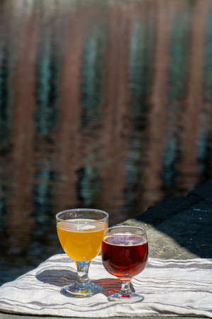 Tasting of Belgian beer on open cafe or bistro terrace with view on medieval houses and canals in Bruges, Belgium in sunny dayの写真素材