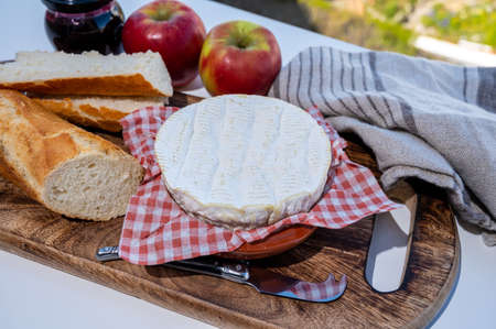 French breakfast with fresh baked baguette bread and camembert chees from Normandy, served outdoor with nice French village viewの写真素材