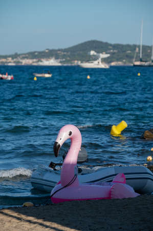 Family summer vacation on French Riviera, France, view pink flamingo inflatable floating toy with blue sea on backgroundの写真素材
