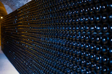 Champagne grand cru sparkling wine production in bottles in rows in dark underground cellars, Reims,...