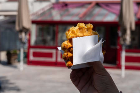 Eating of fresh baked hot Belgian sugar waffles, street food in Brugesの写真素材