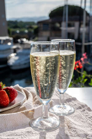 Summer party, pouring of French brut champagne sparkling wine in glasses in yacht harbor of Port Grimaud near Saint-Tropez, French Riviera vacation, Franceの写真素材