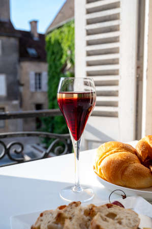 Drinking of Kir Royal, French aperitif cocktail made from creme de cassis topped with champagne,...