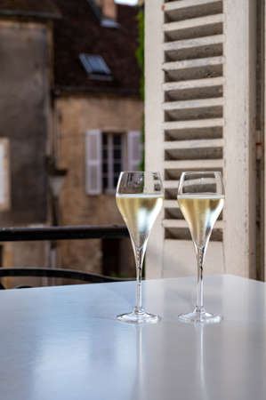 Romantic party with two glasses of white cold champagne sparkling wine with bubbles and view on old street in French villageの写真素材