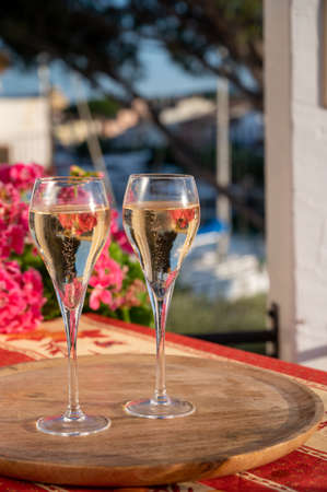 Romantic wedding party with two glasses of white cold champagne, summer flowers and view on yachts and houses of Port Grimaud, French riviera, Franceの写真素材