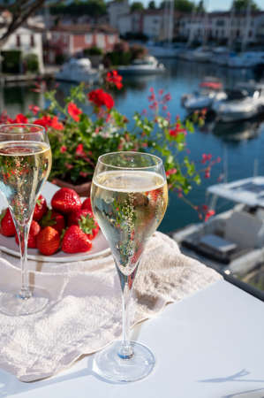 Summer party, pouring of French brut champagne sparkling wine in glasses in yacht harbor of Port Grimaud near Saint-Tropez, French Riviera vacation, Franceの写真素材
