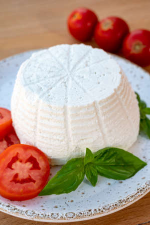 Cheese collection, white Italian soft organic cheese ricotta served with fresh tomatoes and basilの写真素材