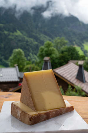 Cheese collection, French cow cheese comte, beaufort, abondance and french mountains village in summer in Haute-Savoie on backgroundの写真素材
