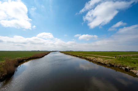 Dutch landscape, polders and water channels in Zeeland, Netherlands in sunny dayの写真素材