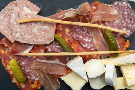 Meat and cheese assortment served on black stone boardの写真素材