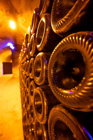 Mathusalem champagne bottles on racks in deep and long undergrounds caves, making champagne sparkling wine from chardonnay and pinor noir grapes in Reims, Champagne, Franceの写真素材