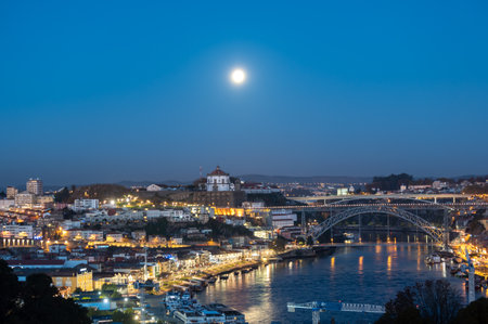 Panoramic view on Douro river and old part of Porto city in Portugal with many lights at nightの写真素材