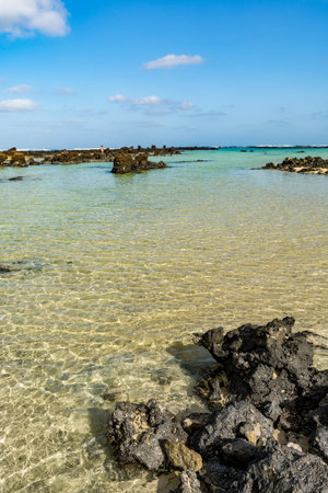 Black lava rocks and water waves of Atlantic ocean, nature landscape on touristic Lanzarote, Canary...