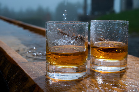 Glasses of strong scotch single malt whiskey and rain water drops, summer in Scotland