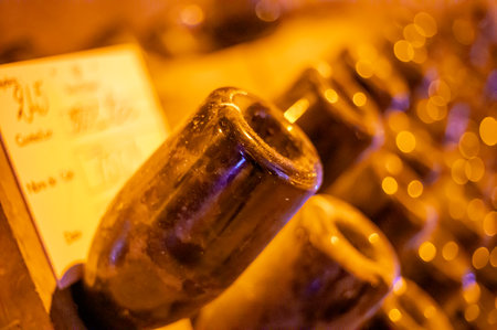Walking in deep and long undergrounds caves with dusty bottles on racks, making champagne sparkling wine from chardonnay and pinor noir grapes in Reims, Champagne, Franceの写真素材