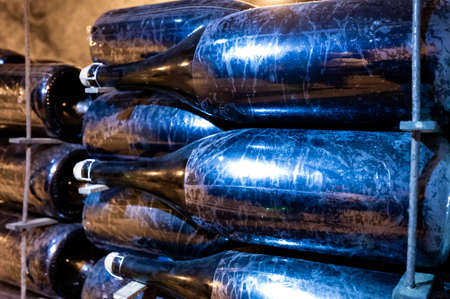 Bottles on racks in deep and long undergrounds caves, making champagne sparkling wine from...