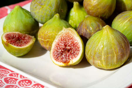 New harvest of fresh ripe sweet fig fruits on white plateの写真素材