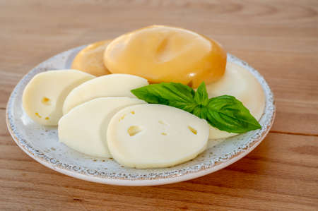 Cheese collection, variety of Italian cow milk cheese flat scamorza on wooden tableの写真素材
