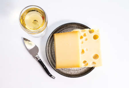 Cheese collection, hard French cheese comte made from cow milk with rind in Franche-Comte region and emmentaler cheese, France, served with white wine close upの写真素材