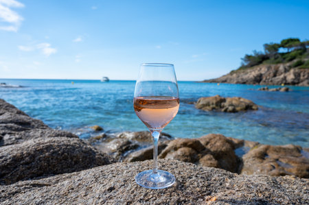 Summer time in Provence, glass of cold rose wine on sandy beach and blue sea water near Saint-Tropez in sunny day, Var department, Franceの写真素材