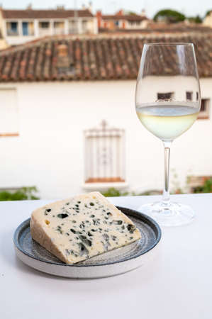 Cheese collection, semi-hard French blue cheese roquefort from Roquefort-sur-Soulzon, France, served with sweet cold white french wine, close upの写真素材