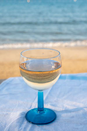Summer time in Provence, drinking of cold dry gris rose wine on sandy beach and blue sea near Toulon, Var department, Franceの写真素材