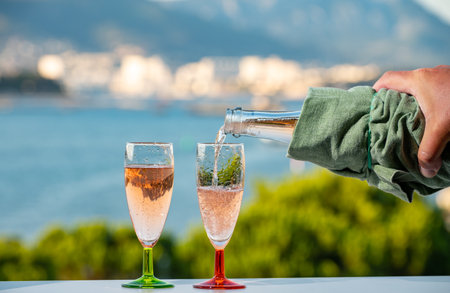 Summer party, pouring of French champagne sparkling wine in glasses with view on fishermen and military harbor of Toulon, Franceの写真素材