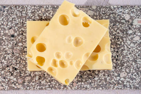 Cheese collection, semi-hard French cheese emmentaler with round holes made from cow milk close up