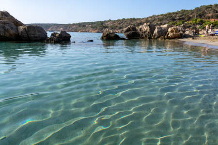 Crystal clear blue water of Mediterranean sea and yellow rocks in on sandy Konnos beach near Protaras, Cyprusの写真素材