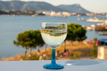 Summer on French Riviera, drinking of cold white wine from Cotes de Provence on outdoor terrase with view on harbor of Toulon, Var, Franceの写真素材
