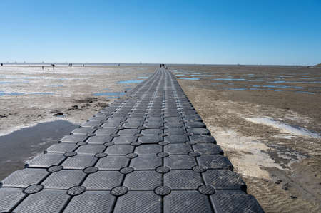 Walking on beach of Harlingen fishermans town on Wadden sea, Friesland, Netherlands at low tideの写真素材