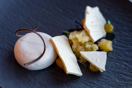 Tasty meringues with apple cream mousse and white chocolate dessert served on black plate