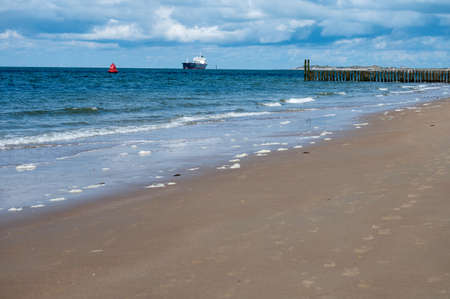 Walking on white sandy beach North sea beach near Zoutelande, Zeeland, Netherlands during low tideの写真素材